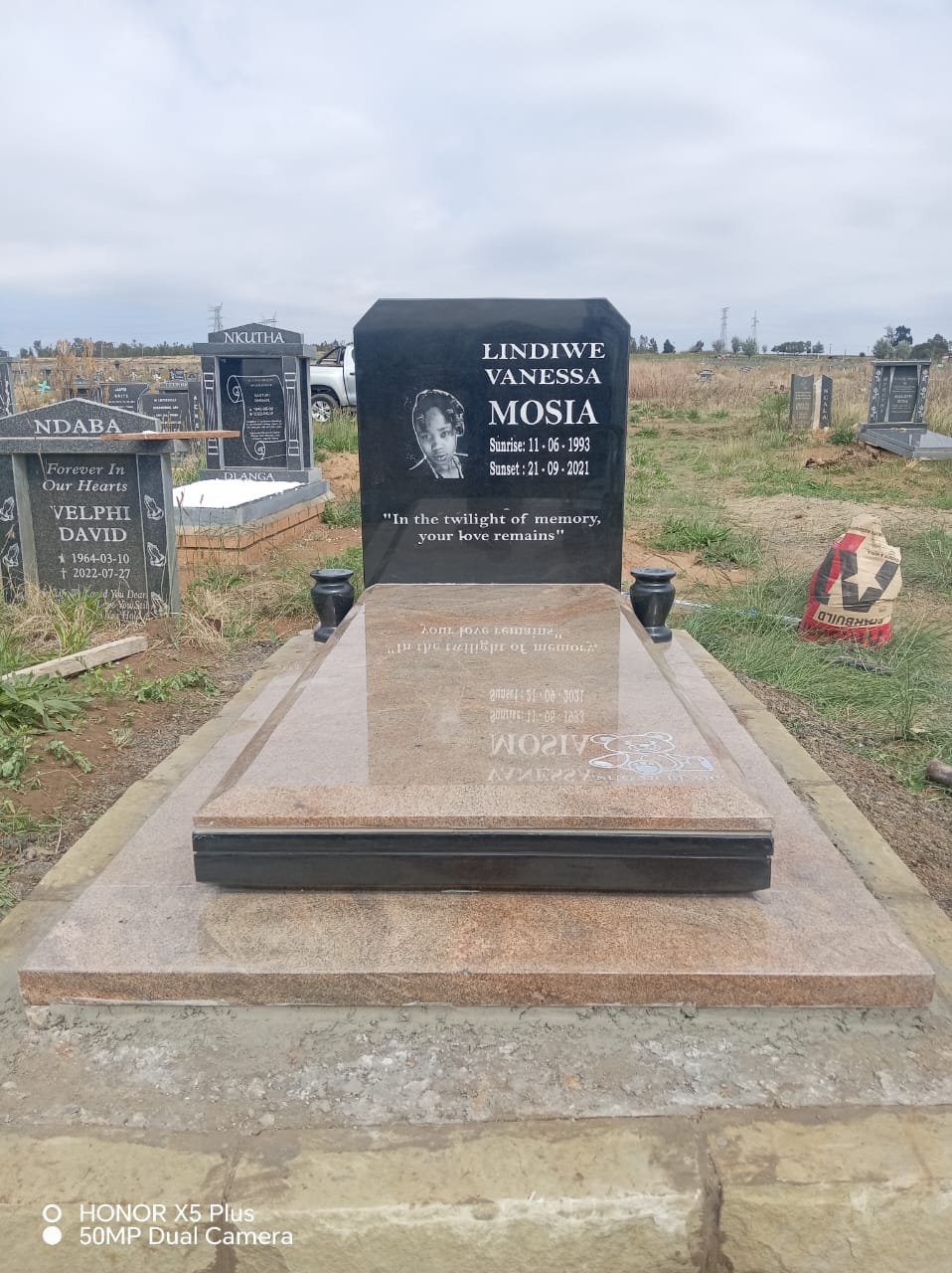 Single tombstone with black headstone and sandstone base