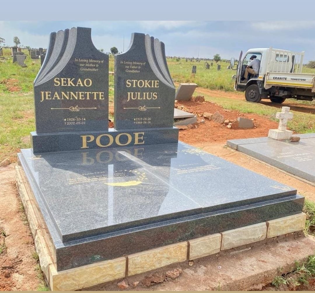 Pooe double tombstone with curved headstones and gold text