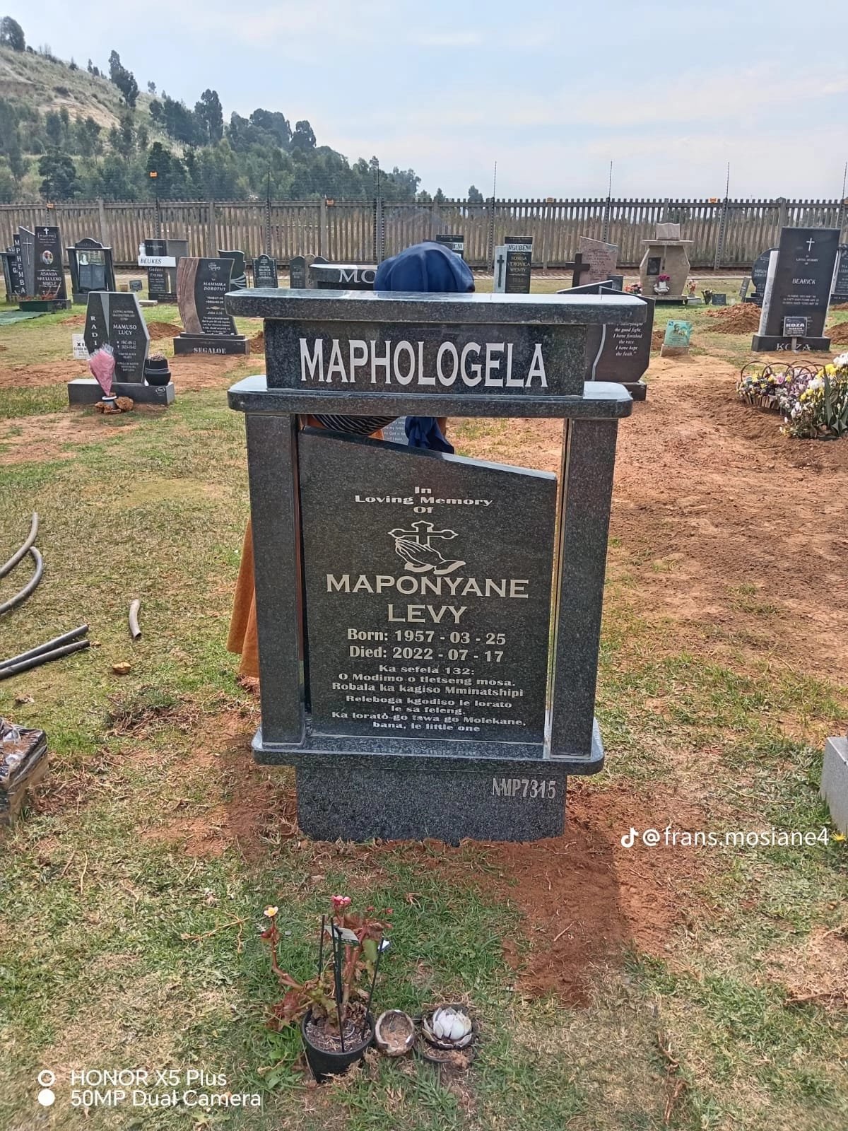 Single memorial with framed headstone and cross accent